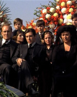 MICHAEL sits with his family - his MOTHER and TOM HAGEN at his sides. AL NERI watches over.