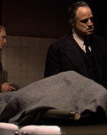 INT NIGHT: FUNERAL PARLOR EMBALMING ROOM. DON CORLEONE: Well, my friend, are you ready to do me this service? / BONASERA: Yes. What do you want me to do?