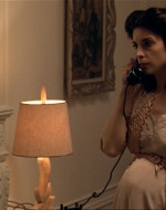 INT DAY: CONNIE AND CARLO'S APPARTMENT. A phone rings. CONNIE, pregnant and wearing a slip and bathrobe, answers it. GIRL'S VOICE: This is a friend of Carlo's. Would you tell him that I can't make it tonight until later. - CONNIE hangs up the phone.
